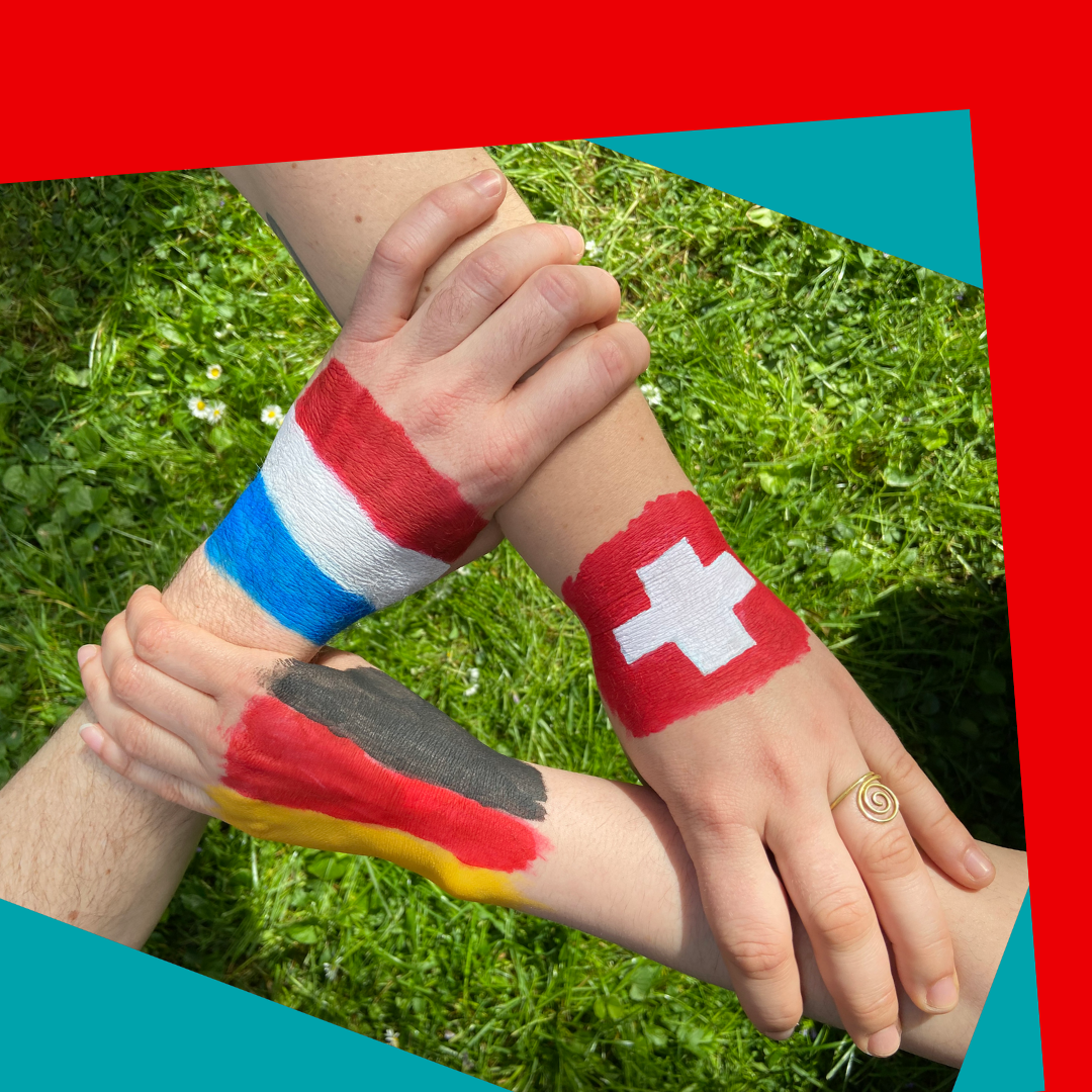 Drei Hände halten sich gemeinsam. Auf den Händen ist jeweils eine Flagge von Frankreich, der Schweiz oder Deutschland aufgemalt.